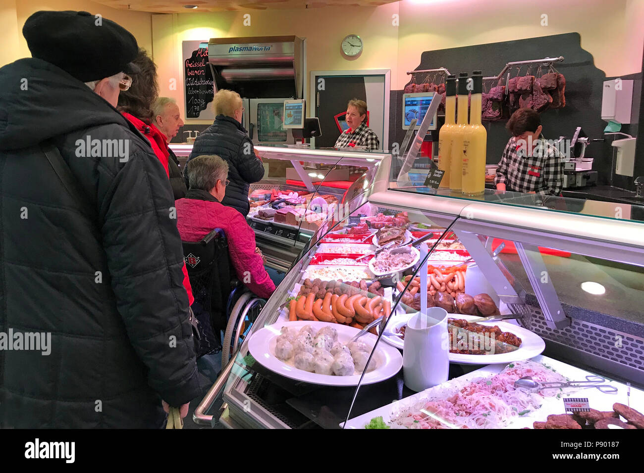 Berlín, Alemania, las personas están de pie en el mostrador de una carnicería Foto de stock