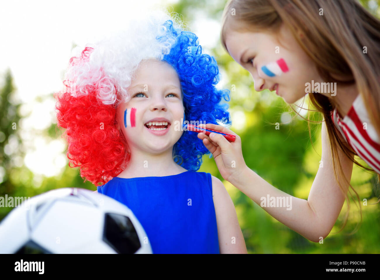 Dos hermanas gracioso, apoyar y animar a su equipo nacional de fútbol durante el campeonato de fútbol Foto de stock