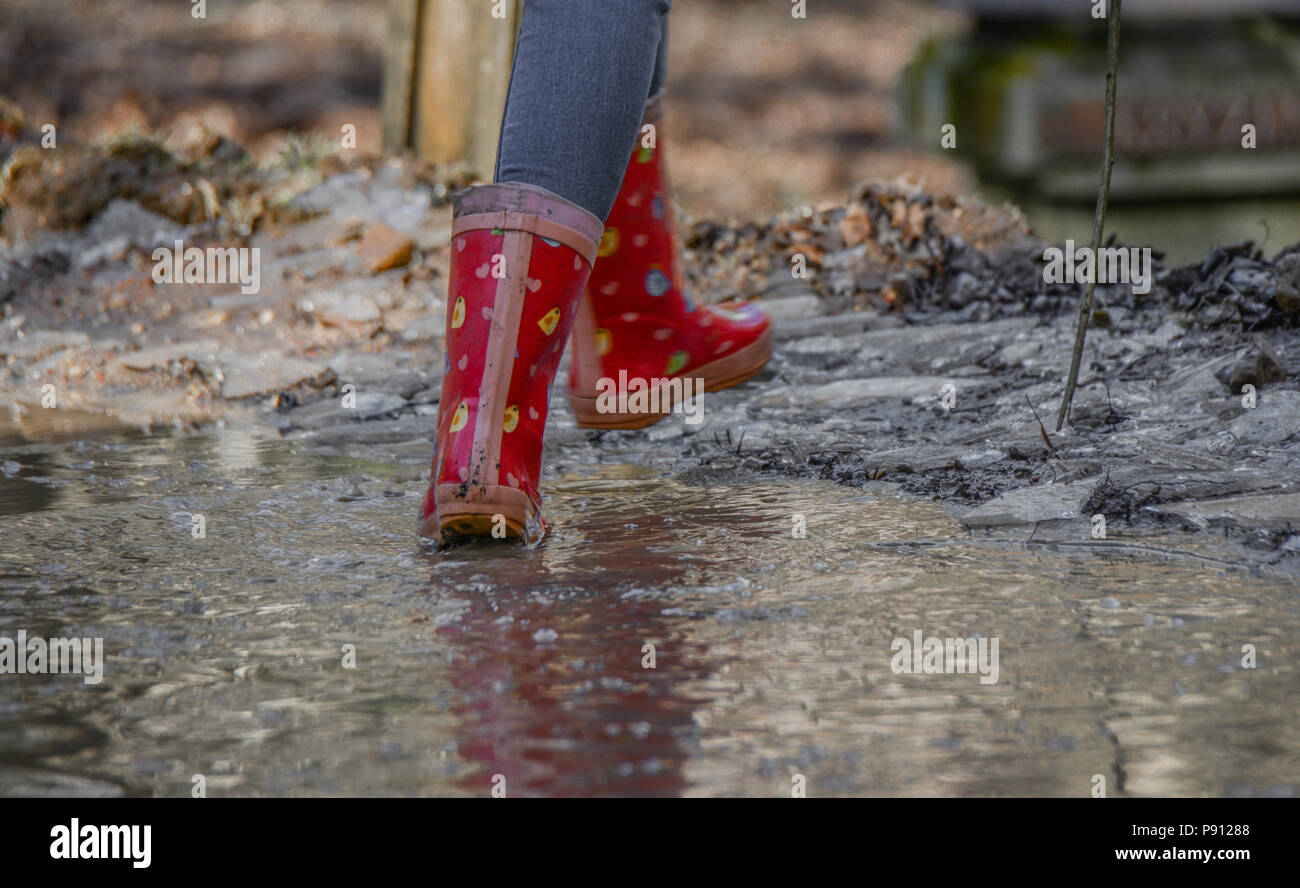 Niña con botas de goma roja caminar bajo la lluvia Fotografía de stock -  Alamy