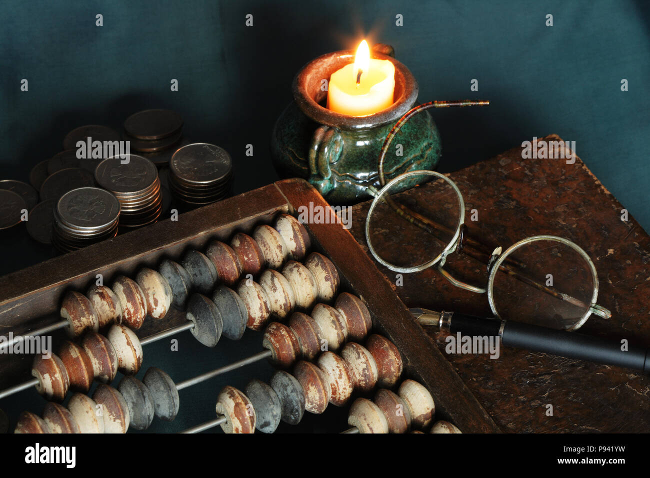 Vintage bodegón con velas y cosas viejas: boliche, monedas, libros, espectáculos Foto de stock