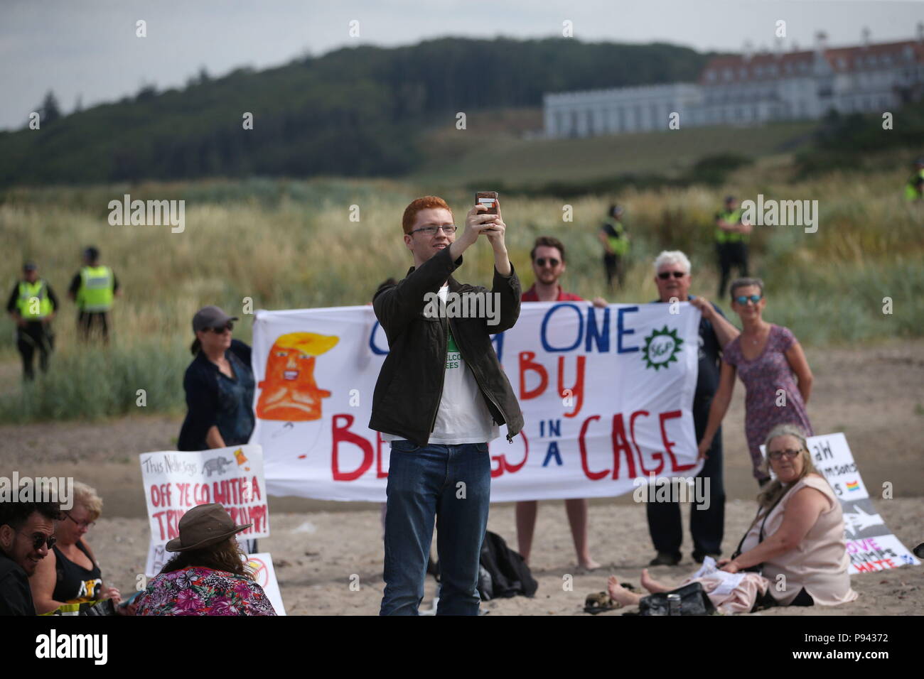 MSP verde Ross Greer toma un selfie con los manifestantes en la playa cerca del Trump Turnberry resort en South Ayrshire, donde el presidente de EEUU, Donald Trump y la primera dama Melania Trump están pasando el fin de semana. Foto de stock
