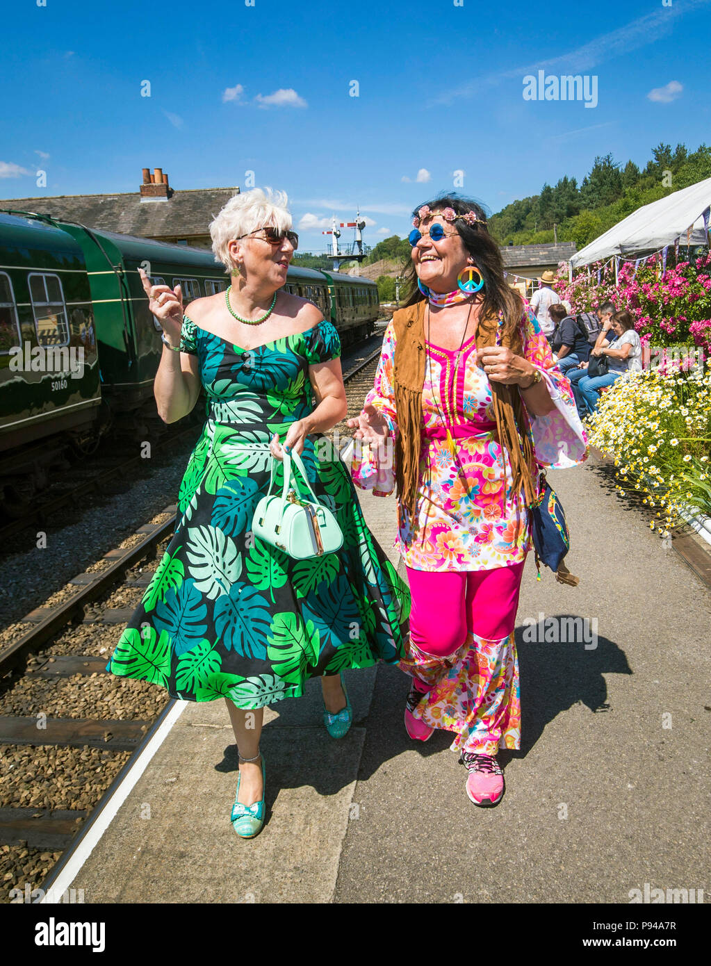 Tracy Horsfield (izquierda) y Susanne Légende (derecha) durante el North Yorkshire Moors Railway 60s Fest 2018 en estación Levisham en Yorkshire. Foto de stock