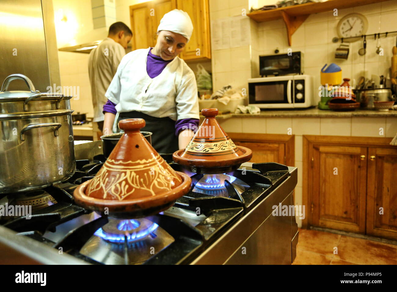 Marrakech, Marruecos - Abril 2016: cocinero mujer mientras cocina marroquí tagine de carne con fechas y almendras. Foto de stock