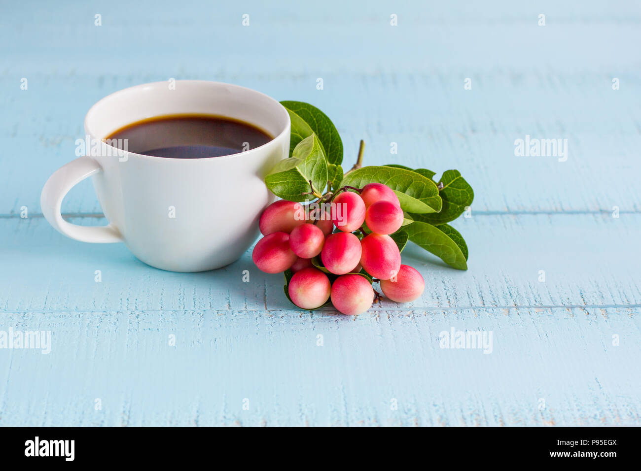 https://c8.alamy.com/compes/p95egx/el-blanco-de-la-taza-de-cafe-con-cafe-negro-y-frutas-en-mesa-de-madera-p95egx.jpg