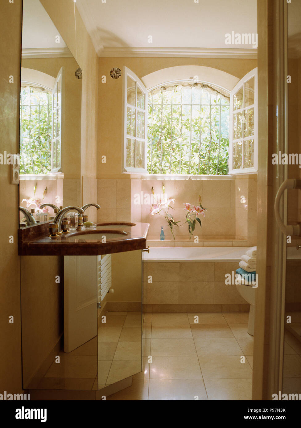 Ventanas abiertas sobre la bañera en francés país baño con lavabo en espejo  tocador Fotografía de stock - Alamy