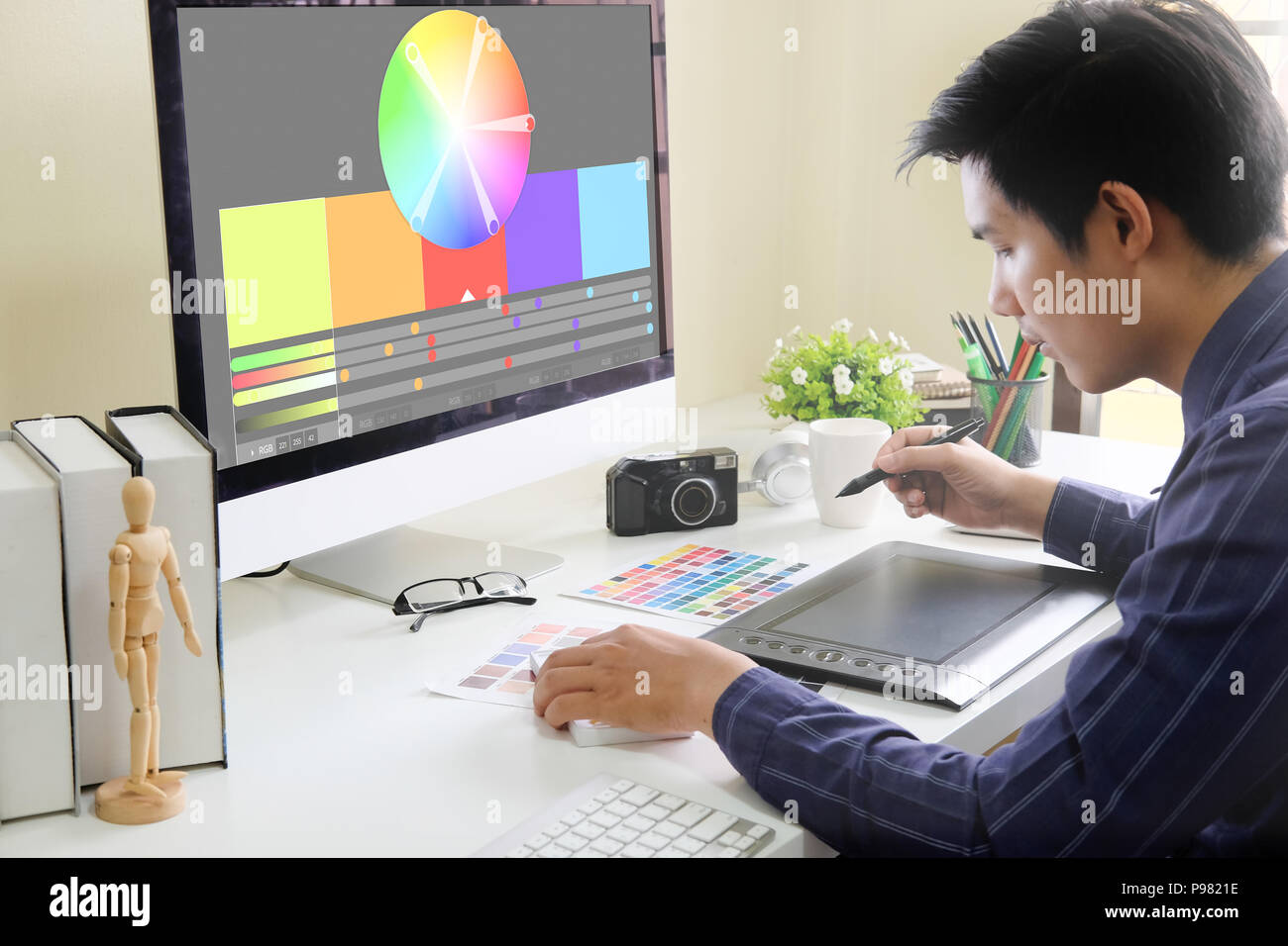 Diseñador gráfico que trabaja en tableta digital en el lugar de trabajo creativo. Foto de stock