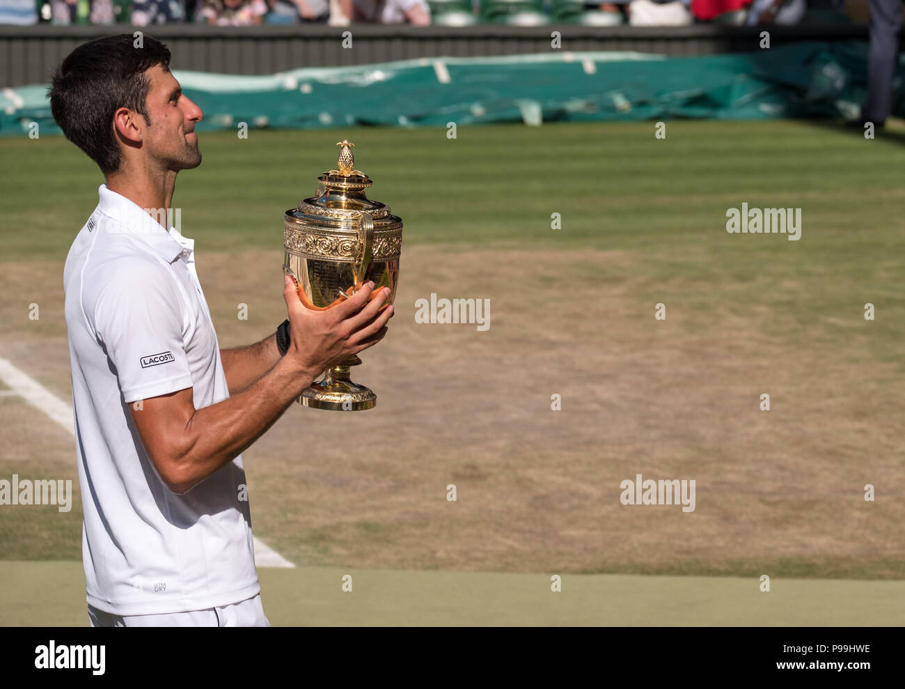 Novac Djokovic, el serbio, el jugador gana el torneo de Tenis de Wimbledon por cuarta vez. En la foto que está en el perfil, sosteniendo su trofeo en el centro de la cancha. Foto de stock