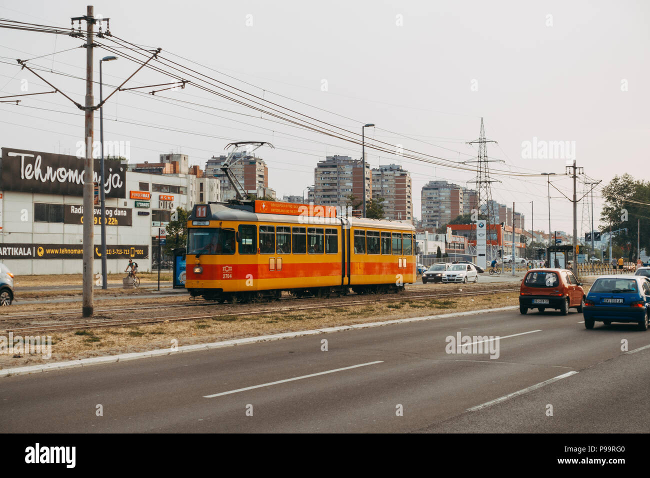 Hay un tranvía que pasa el tráfico en la mediana de la carretera en Belgrado, Serbia Foto de stock