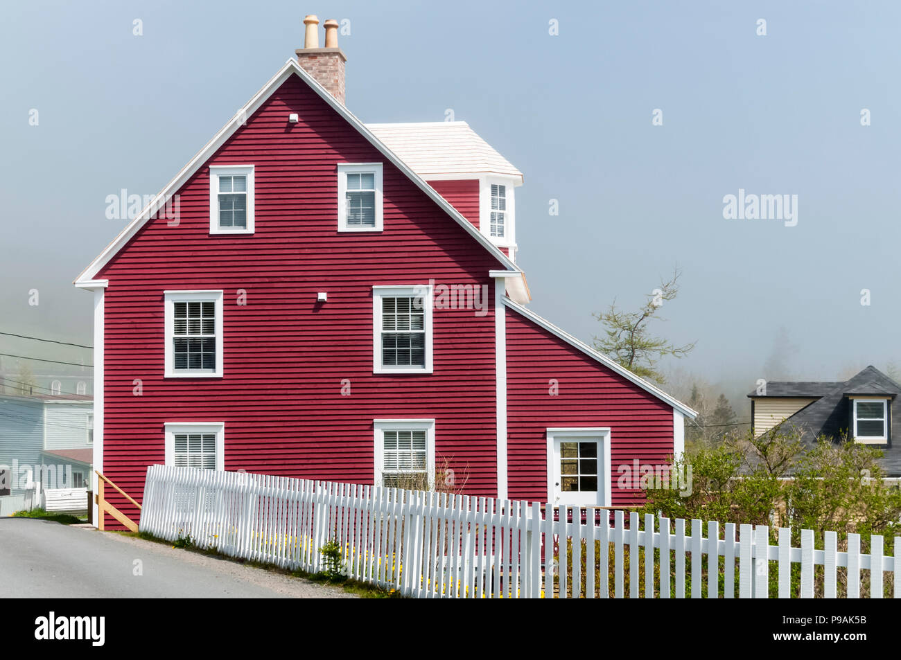 Un rojo weatherboarded casa en niebla en Trinidad, Terranova Foto de stock