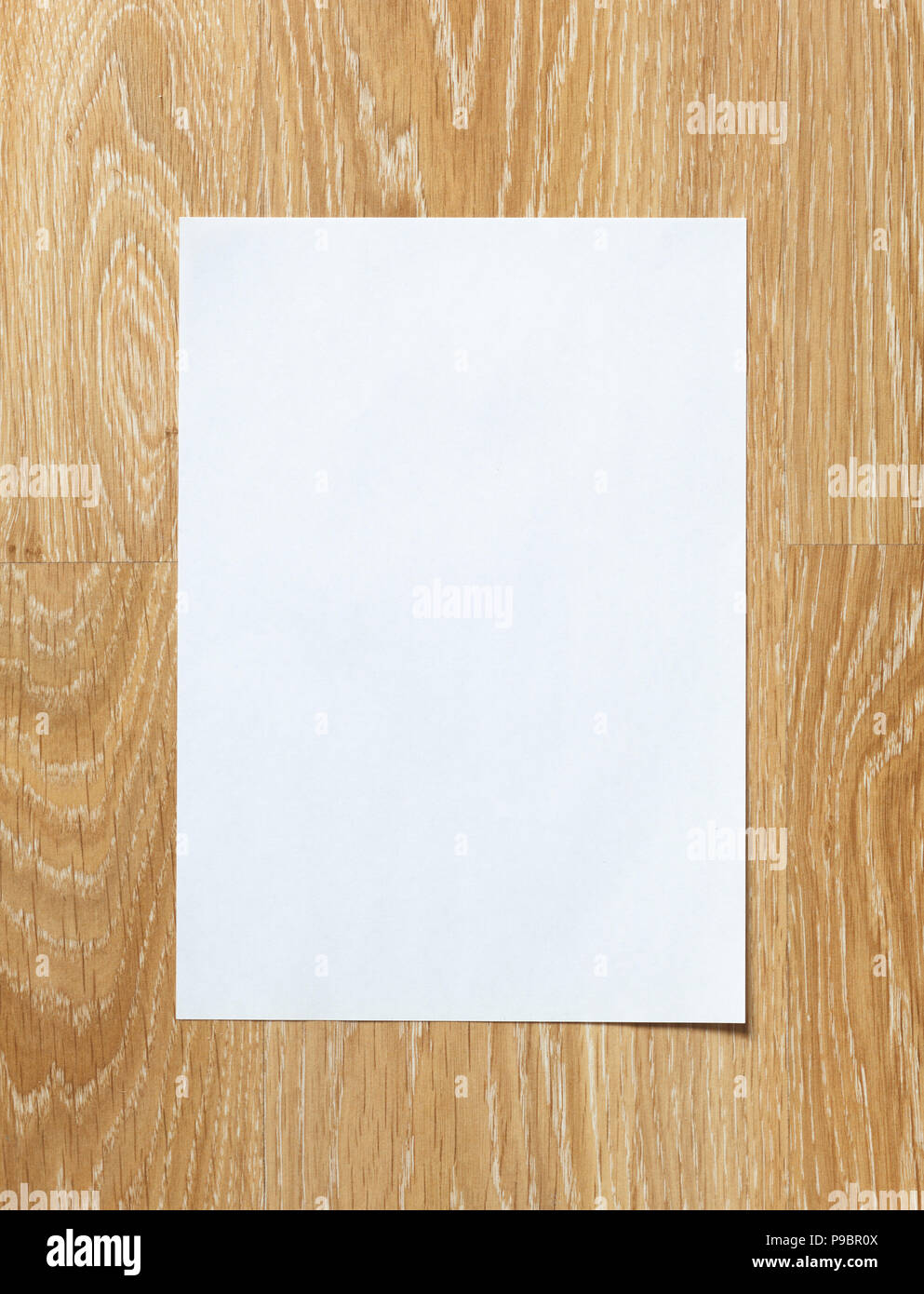 Hoja de papel en blanco sobre fondo de madera con orientación vertical Foto de stock