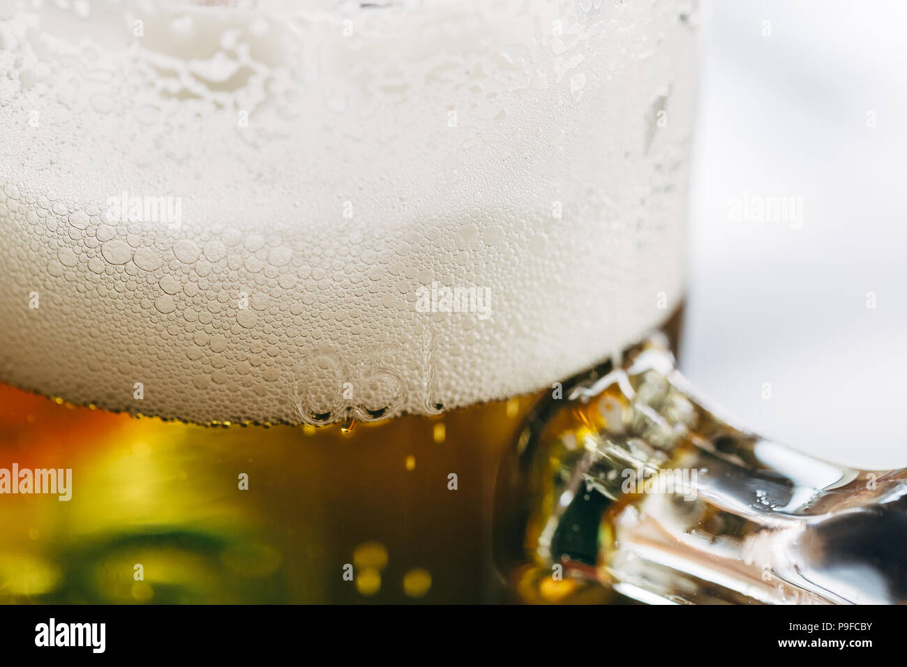 Cerca de un vaso de medio litro de cerveza con espuma espumosa en la parte superior. Foto de stock