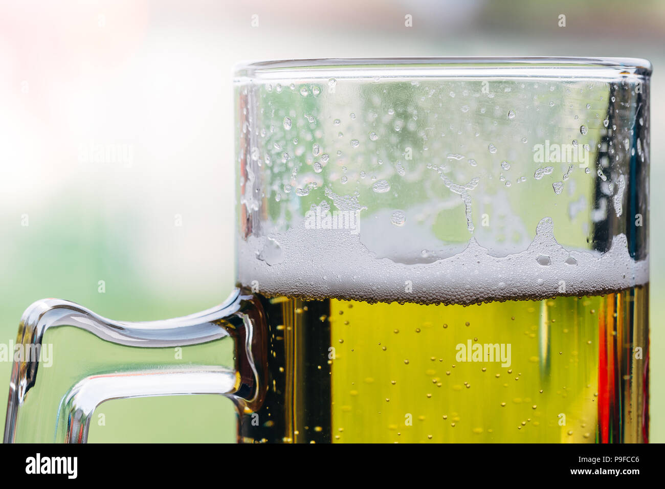 Primer plano de un vaso de cerveza con espuma en la parte superior. Foto de stock
