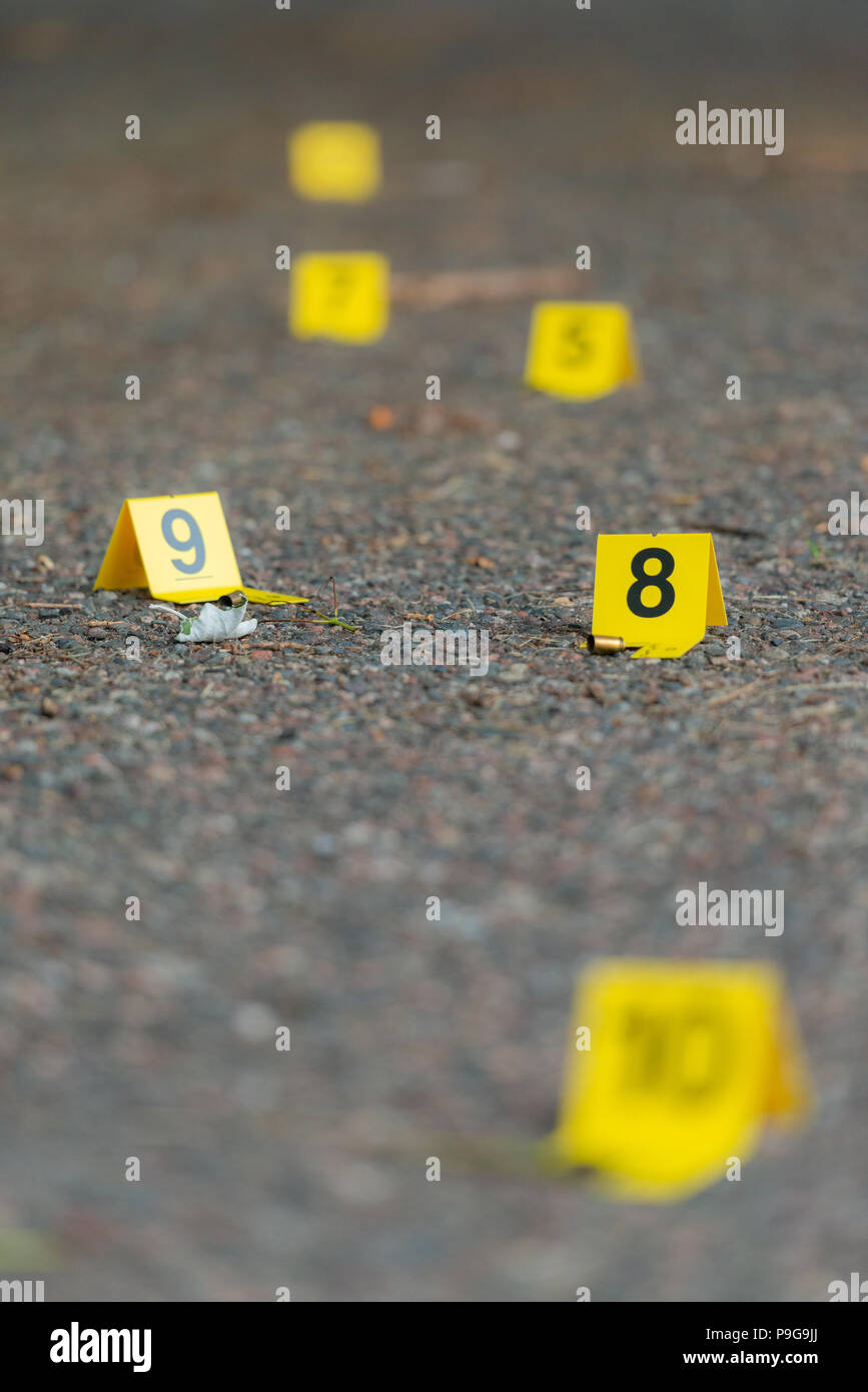 Los marcadores de la escena del crimen en el hormigón con una profundidad de campo limitada. Foto de stock