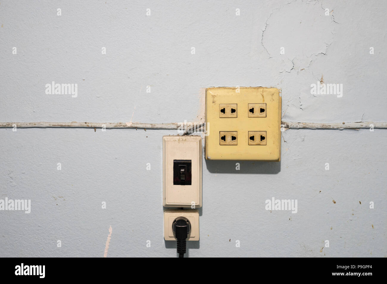 Viejo y polvo de interruptores y enchufes de electricidad con el cable en  el grunge pared azul Fotografía de stock - Alamy