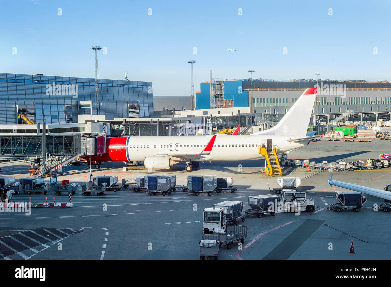 Avión de carga estacionado en el aeropuerto de Copenhague edificio, escaleras y portaequipajes cerca Foto de stock