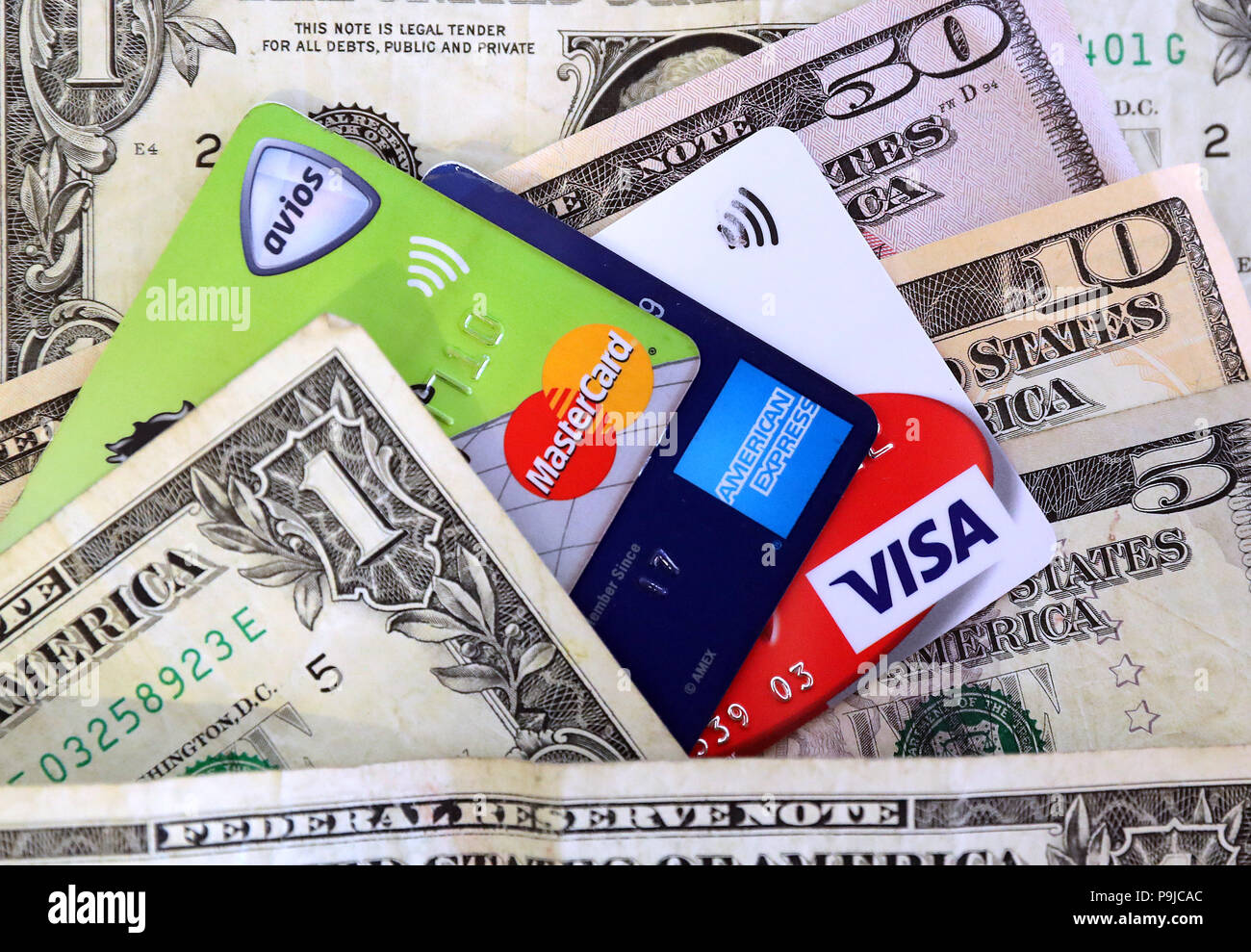 Una Mastercard, Visa y American Express tarjetas de crédito y débito rodeado de dólares EE.UU. Foto de stock
