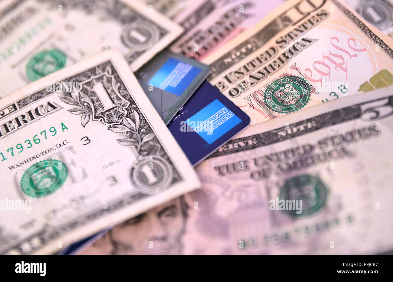 Dos tarjetas de crédito American Express rodeado de dólares EE.UU. Foto de stock
