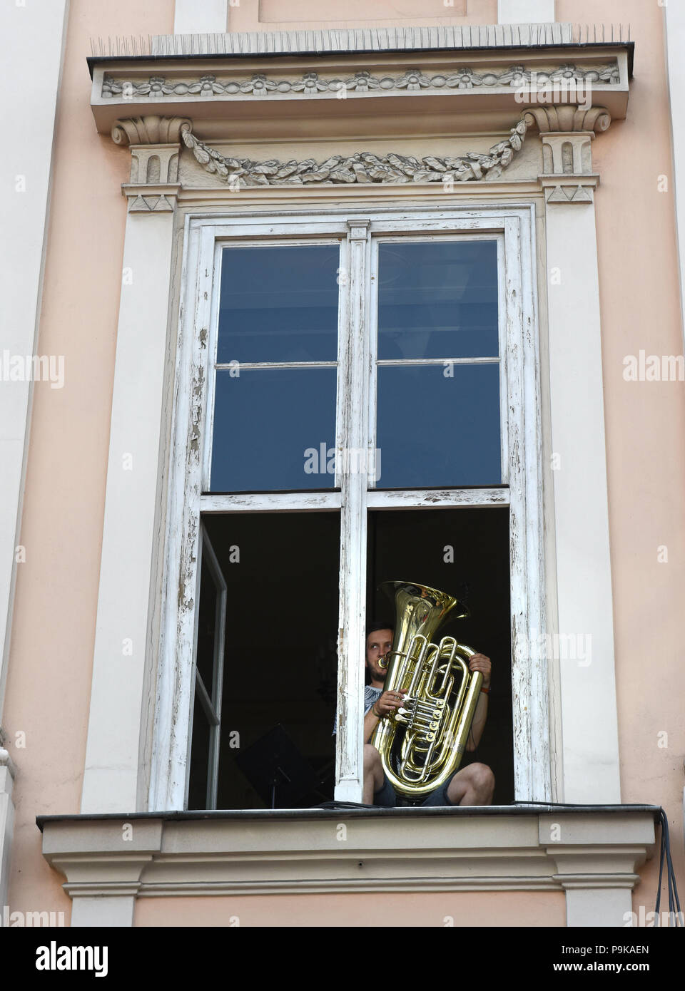 Músico tocando realizar desde Windows Apartamento En Cracovia, Polonia. Foto de stock