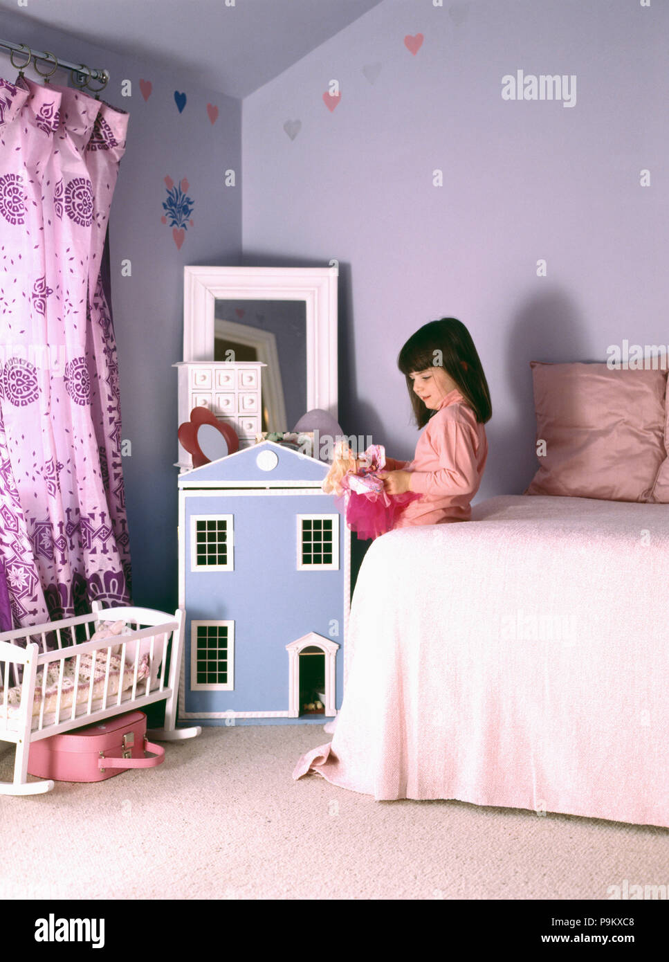 La pequeña niña jugando en color lila dormitorio SÓLO PARA USO EDITORIAL  Fotografía de stock - Alamy