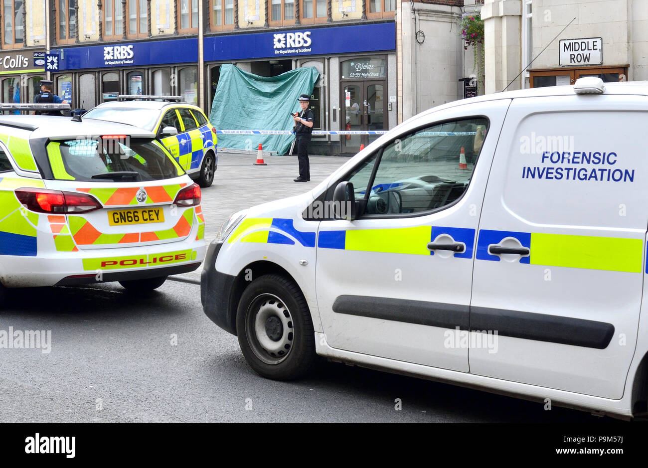 Maidstone, Kent, UK. El 19 de julio, 2018. Varios coches de policía, una ambulancia y equipo de investigación forense rodean el Royal Bank of Scotland sucursal en Maidstone High Street tras la muerte de un áspero durmiente. Una gran área de Jubileo Square en el centro de la ciudad fue acordonado tras el descubrimiento del cuerpo en la portada de la RBS sucursal esta mañana. La policía fue llamada alrededor de las 8:45am - la muerte no está siendo tratado como sospechoso. Crédito: PjrNews/Alamy Live News Foto de stock