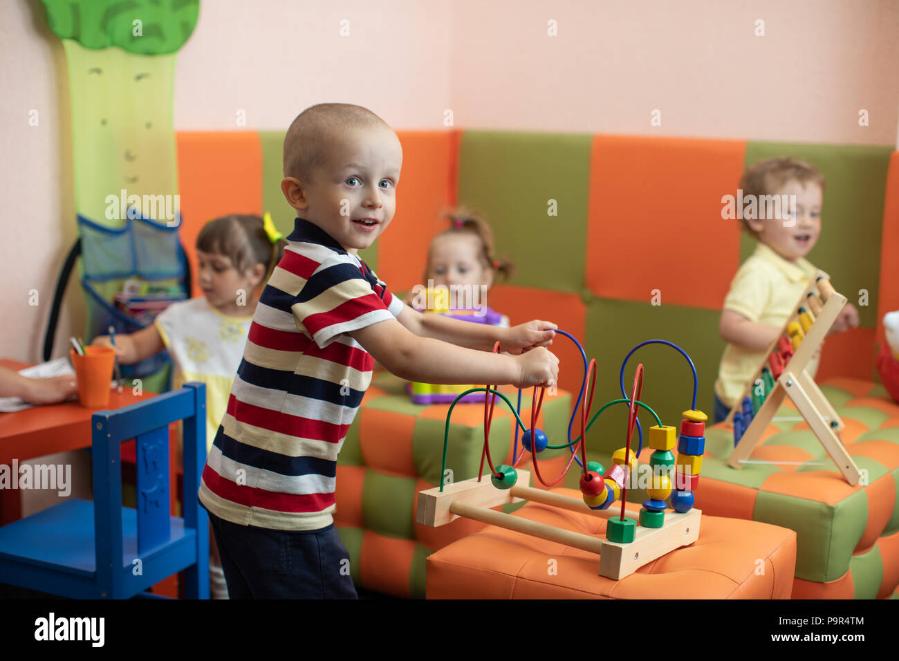 Un grupo de niños jugando en el jardín de infantes o guardería Foto de stock