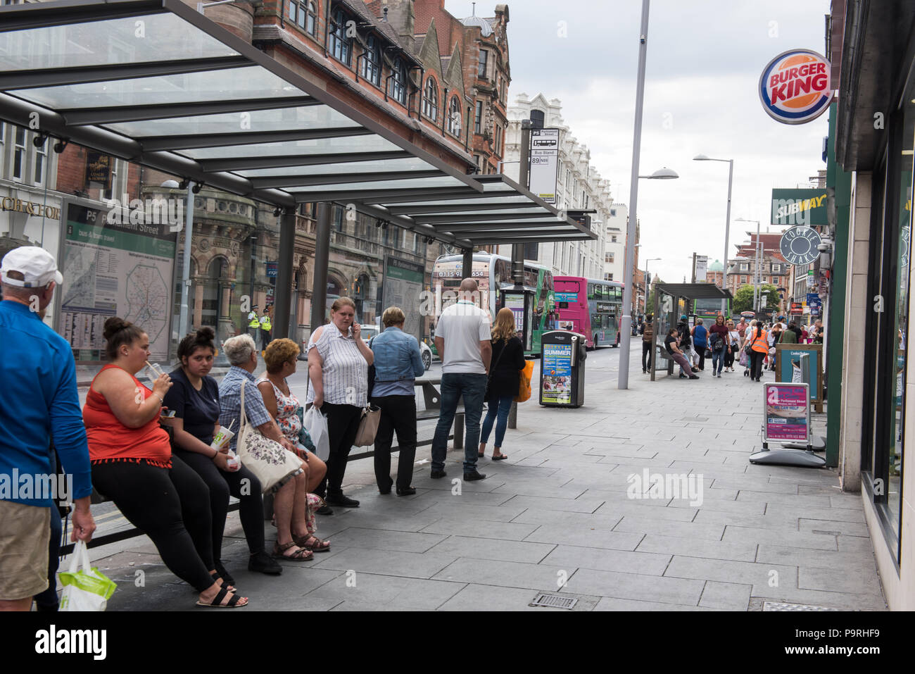 Gente esperando en una parada de autobús en Upper Parliament Street en la ciudad de Nottingham, Nottinghamshire Inglaterra Foto de stock