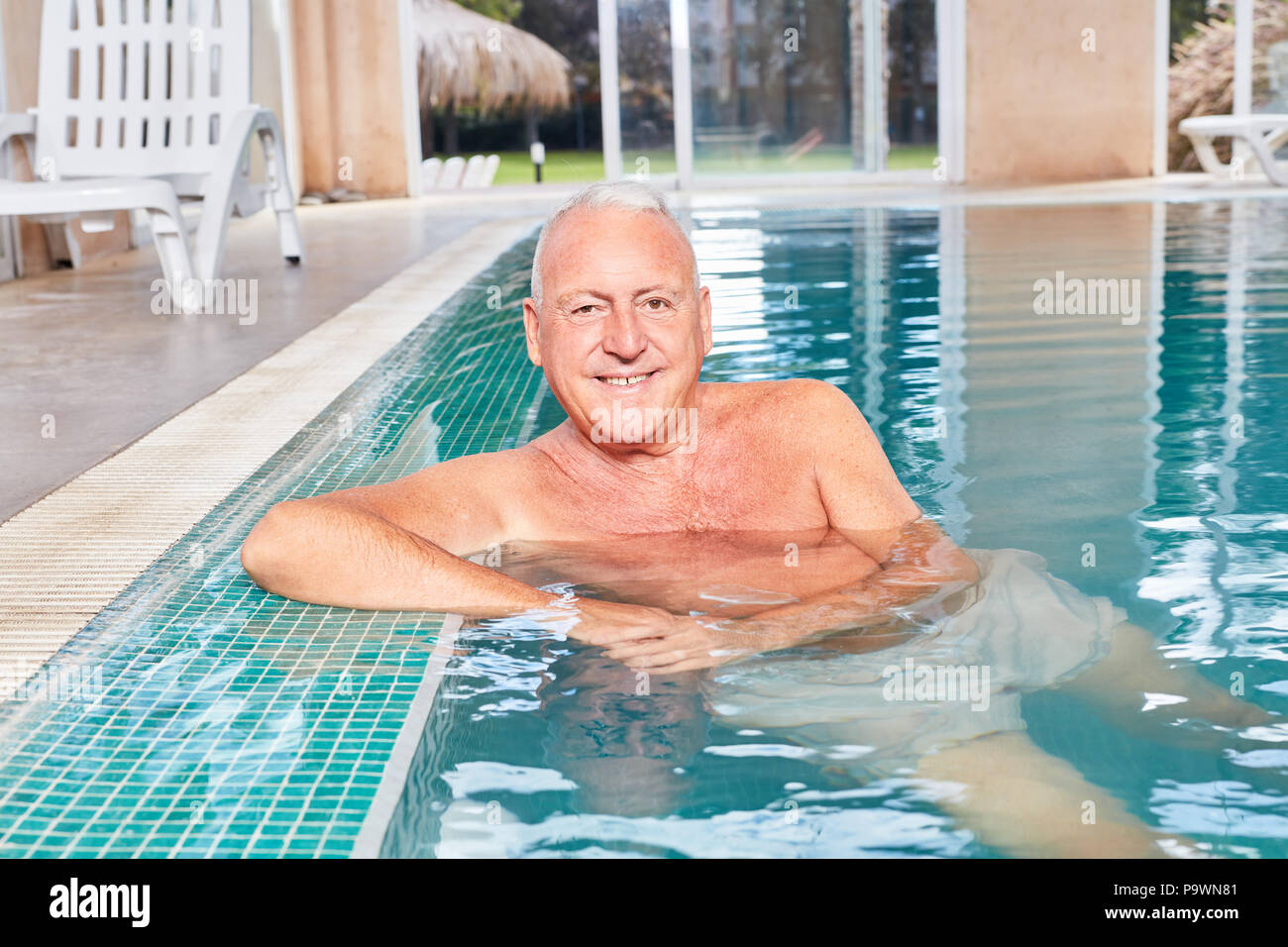 Senior sonriente al hombre como un jubilado vital en la piscina de ocio Foto de stock