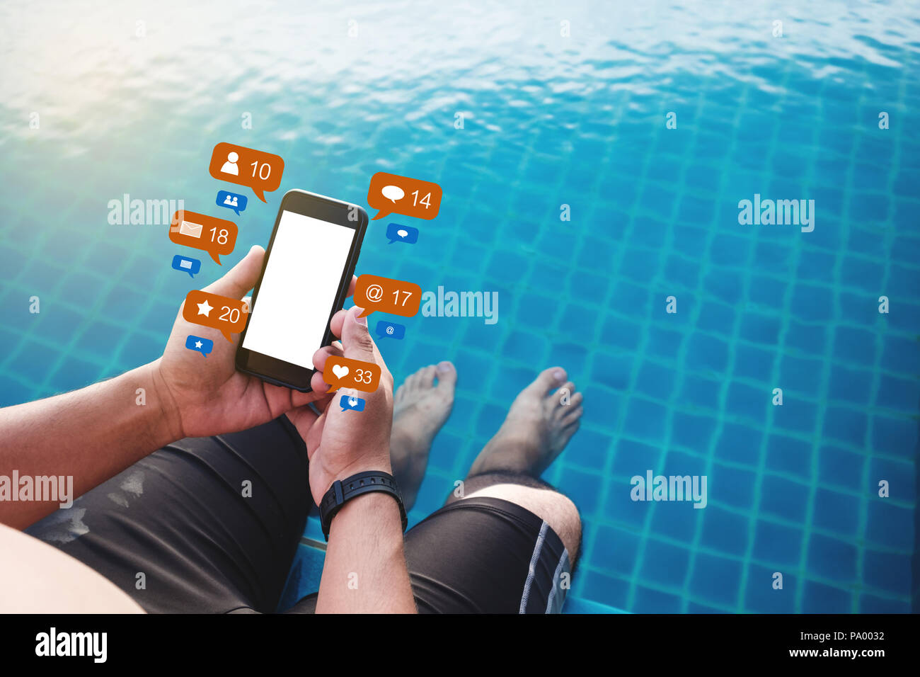 Hombre utilizando un teléfono móvil junto a la piscina en verano con los medios sociales y los iconos de notificación de mensajes en línea, pantalla en blanco Foto de stock