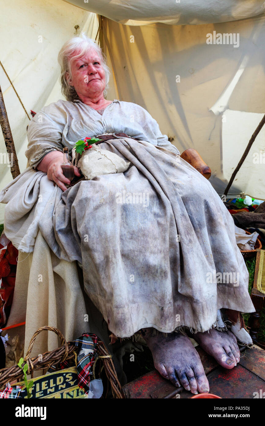 Mujer mayor, 60s, vestida con ropa de estilo Victoriano asquerosos como  Polly Allman desde las voces de Londres victoriano historia viva grupo.  sentado en una silla Fotografía de stock - Alamy