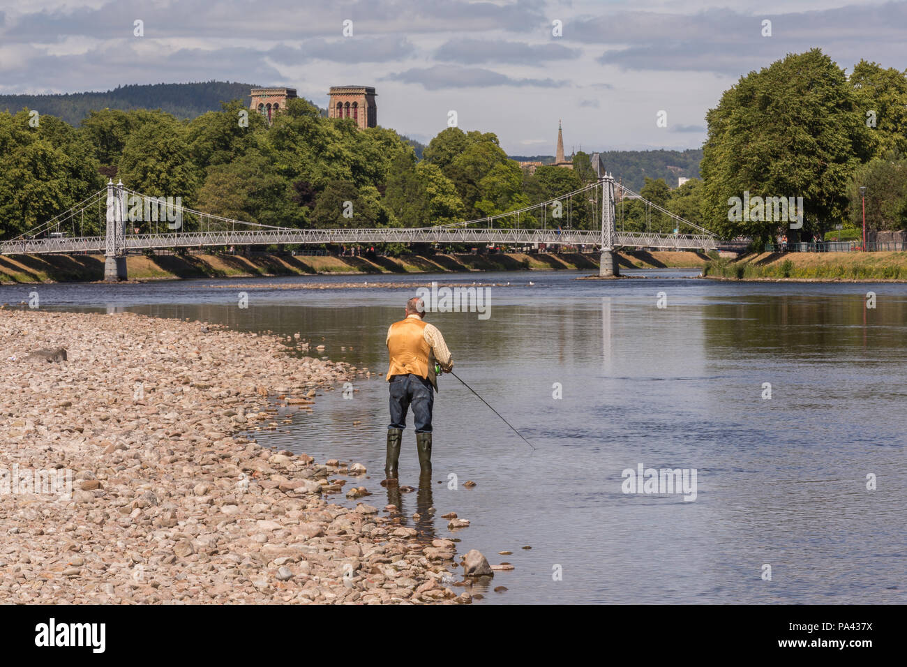 Pescador con mosca se puede pescar en el río Ness en la ciudad de Inverness, Scotland, Reino Unido Foto de stock