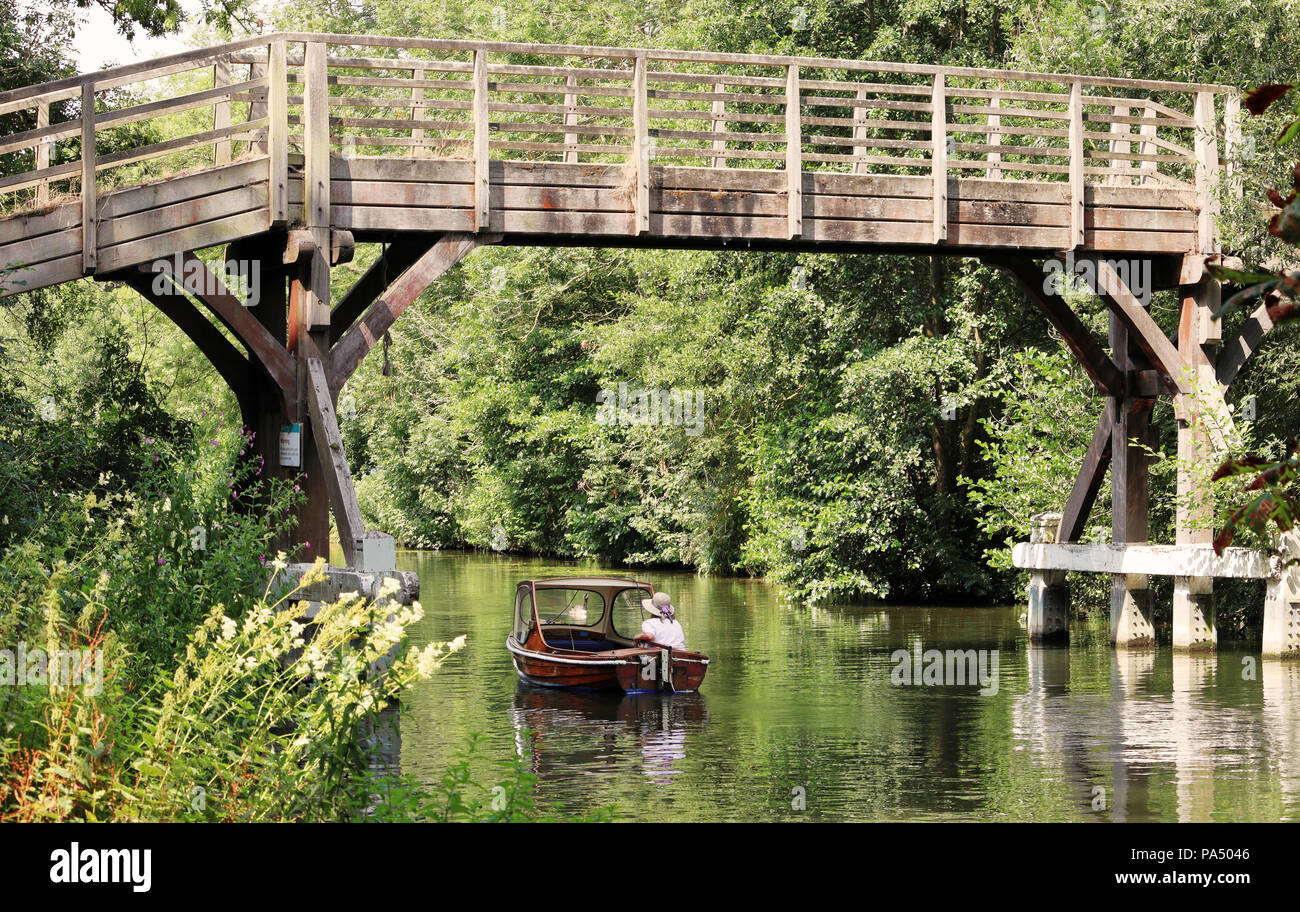 Pasarela de madera sobre el río Támesis en Hurley con dama en un motor ir debajo de lanzamiento Foto de stock