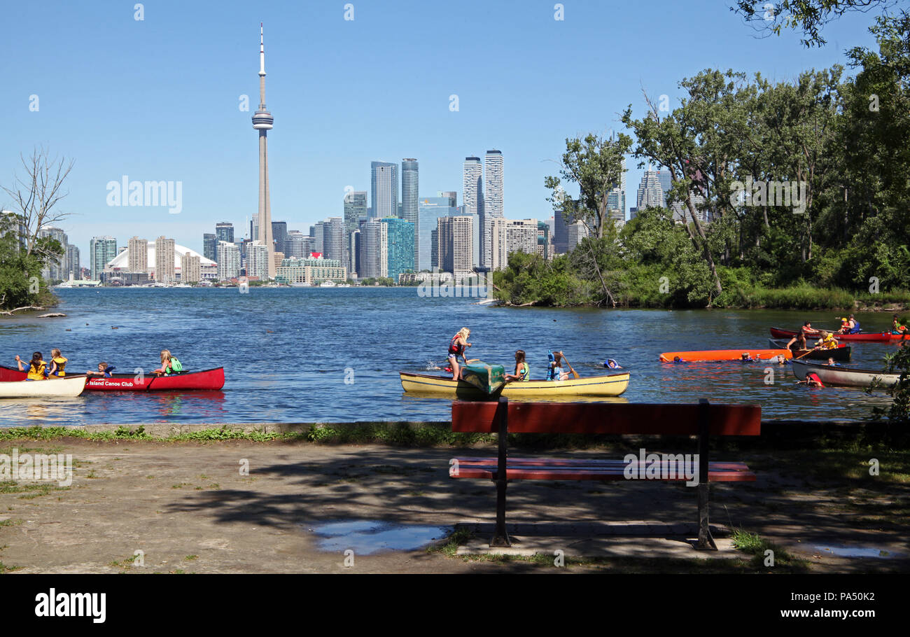 Los niños en canoas en islas de Toronto con el horizonte de la ciudad de Toronto, en el fondo, Canadá Foto de stock