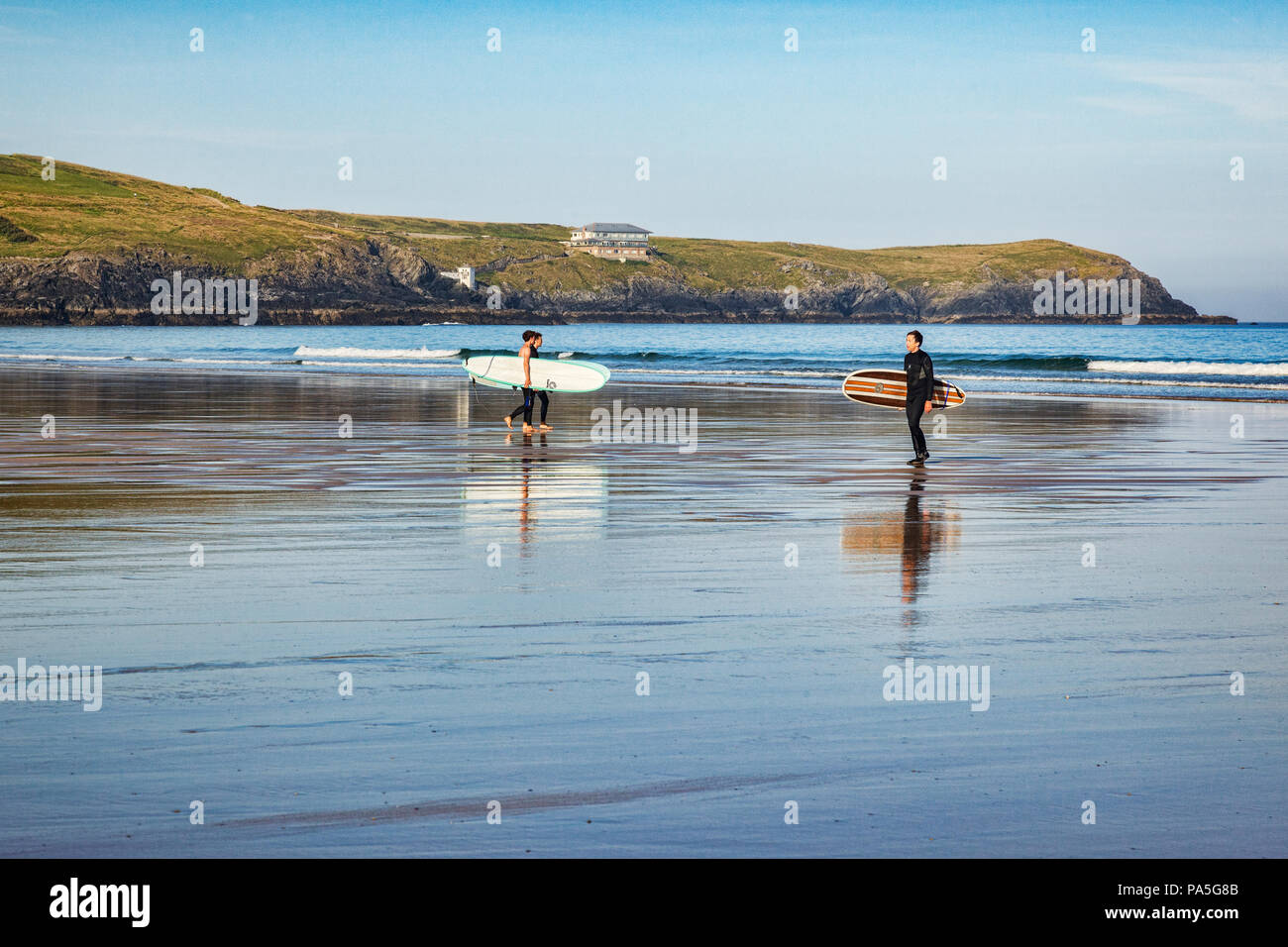 El 24 de junio de 2018: Newquay, Cornwall, Reino Unido - Surfers llevando sus tablas en la playa Fistral. Foto de stock