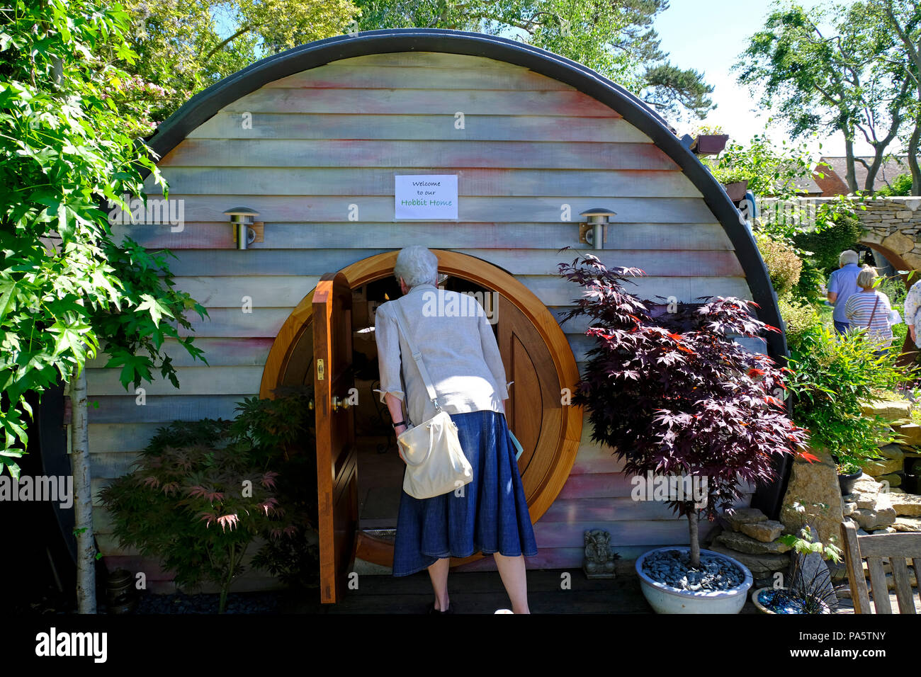 Dama Hobbit asomándose al jardín de la casa casa de veraneo, como Foto de stock