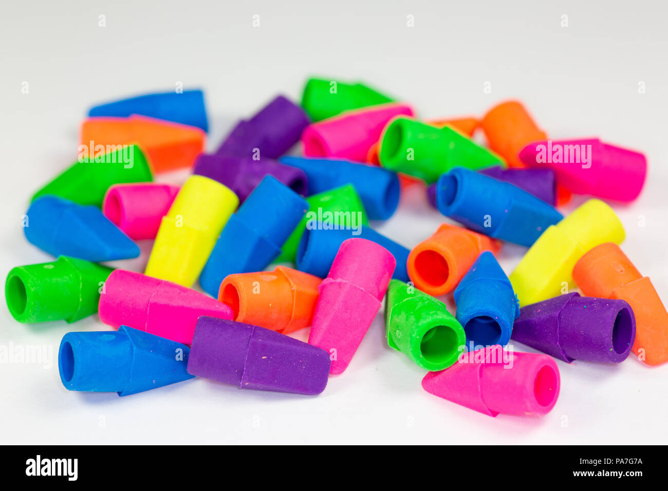 Coloridas gomas de borrar o borradores de los lápices recargada sobre una superficie blanca Foto de stock