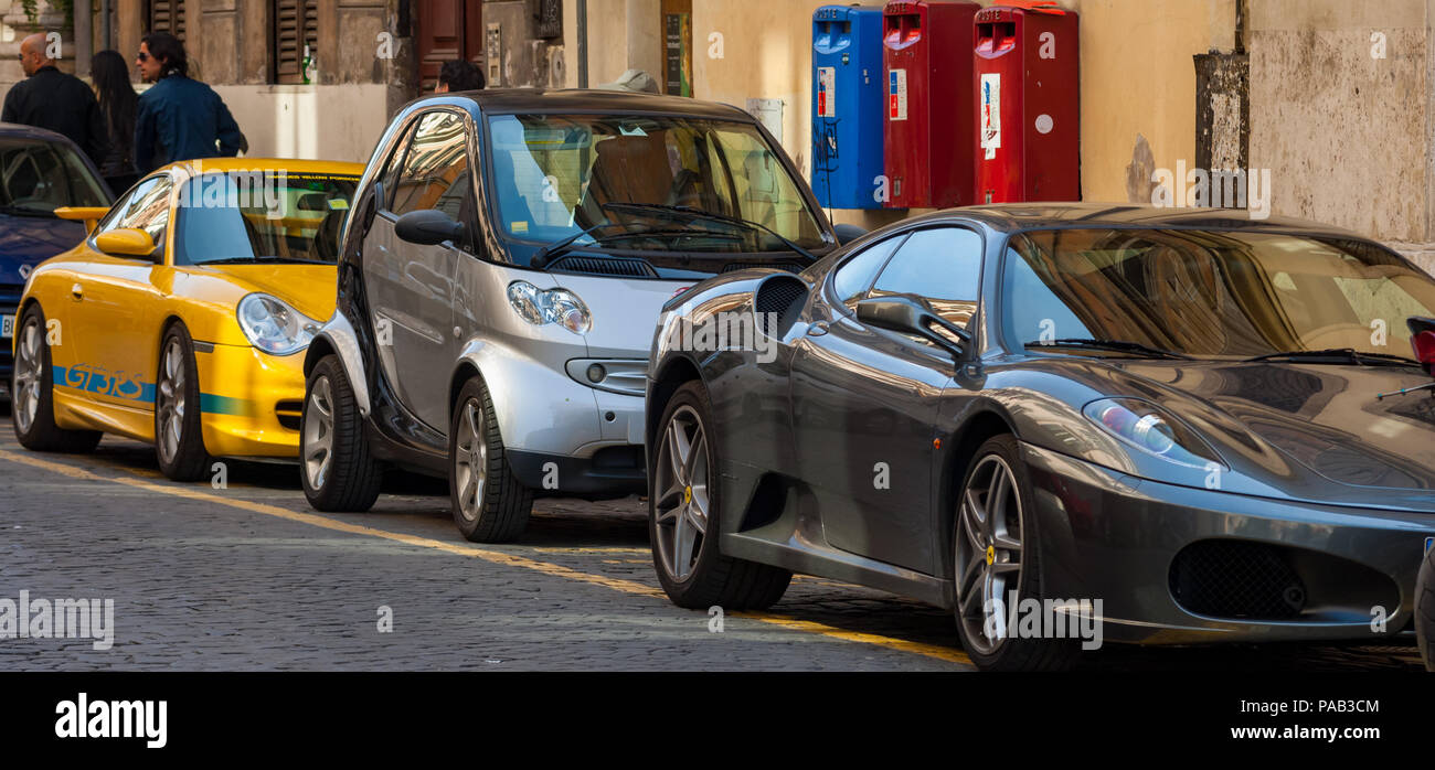 Los contrastes de automovilismo, un Porsche GT3 RS, Smart fortwo, y Ferrari F430 estacionado en una línea en la Via del Babuino, frente a la Piazza del Popolo, en Roma Foto de stock