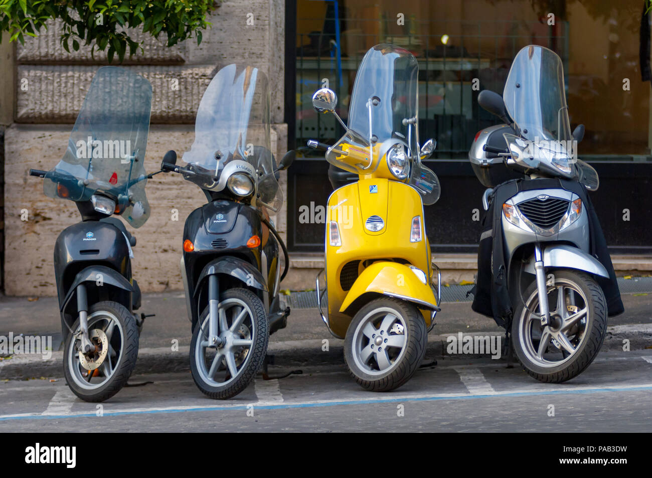 Atrévete a ser diferente. Una fila de perfectamente negro estacionado scooters y uno que se atreve a ser diferente, en una calle de Roma. Foto de stock
