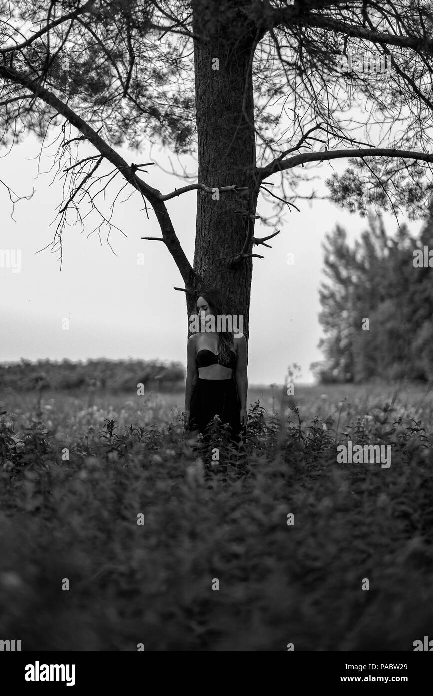 Monocromo foto de mujer europea solas en el bosque. El humor y la soledad concepto místico Foto de stock