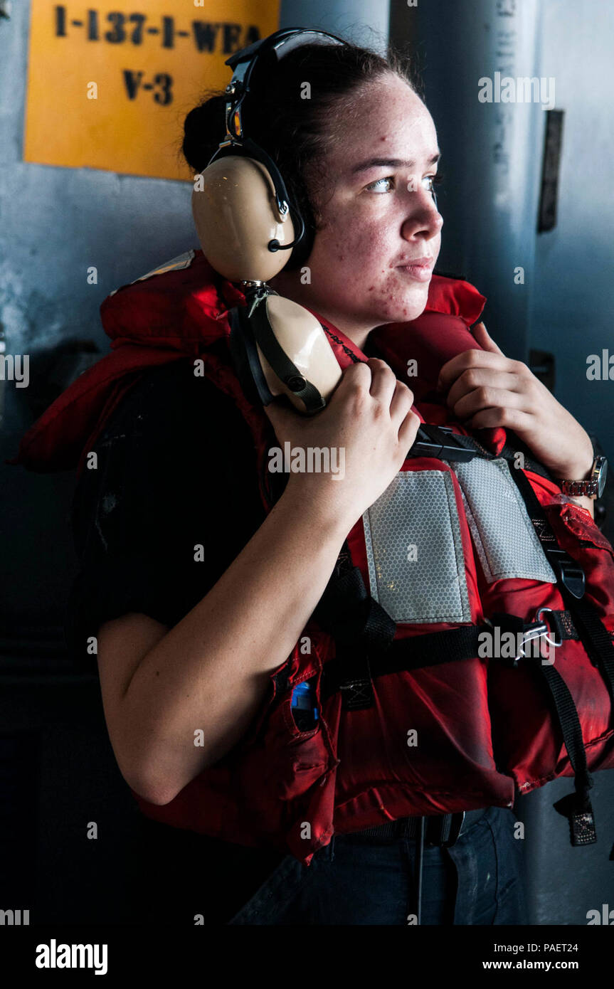 Mar de Filipinas (Sept. 11, 2016) marinero Kendra Robletto, de Stockton, California, usa un sonido-powered teléfono en el hangar de la bahía de la Marina sólo desplegadas, el portaviones USS Ronald Reagan (CVN 76), durante un reabastecimiento en alta mar con el comando de Transporte Marítimo Militar (MSC) y municiones de carga seca buque USNS Charles Drew (T-AKE 10). Los civiles no combatientes, con tripulación de buque MSC es parte de las líneas de suministro a los buques de la Marina en el mar, y estratégicamente proporcionan combustible, alimentos, municiones, piezas de repuesto, el correo y otros suministros en todo el mundo. Ronald Reagan, el Carrier Strike Group 5 (CSG) flagsh 5 Foto de stock