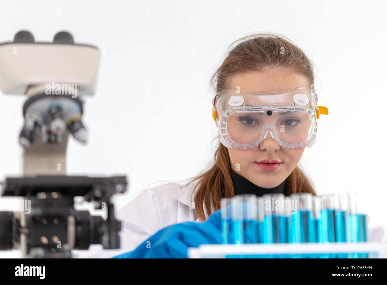 Los científicos chica están mezclando productos químicos o haciendo algún experimento para desarrollar la medicina en laboratorio. Foto de stock