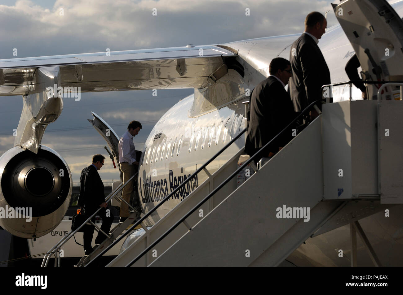 Los pasajeros con equipaje de mano a bordo de un Lufthansa Regional BAE 146  Avro RJ-85 estacionados en la ciudad de Londres Fotografía de stock - Alamy