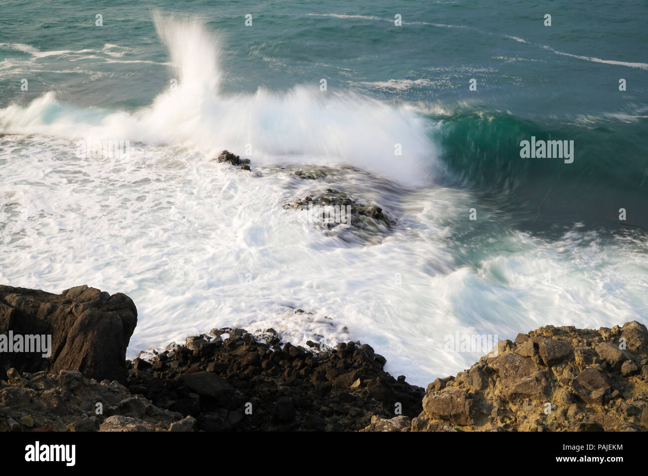 Ola está golpeando las rocas en la costa Foto de stock