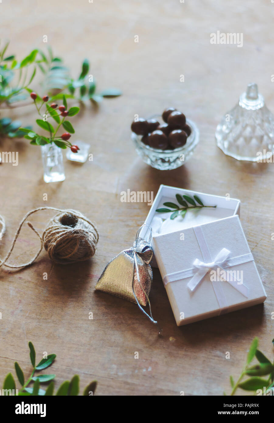 Envolver los regalos de Navidad. Bolsa de plata brillante y caja blanca con  lazo en la mesa de madera Fotografía de stock - Alamy