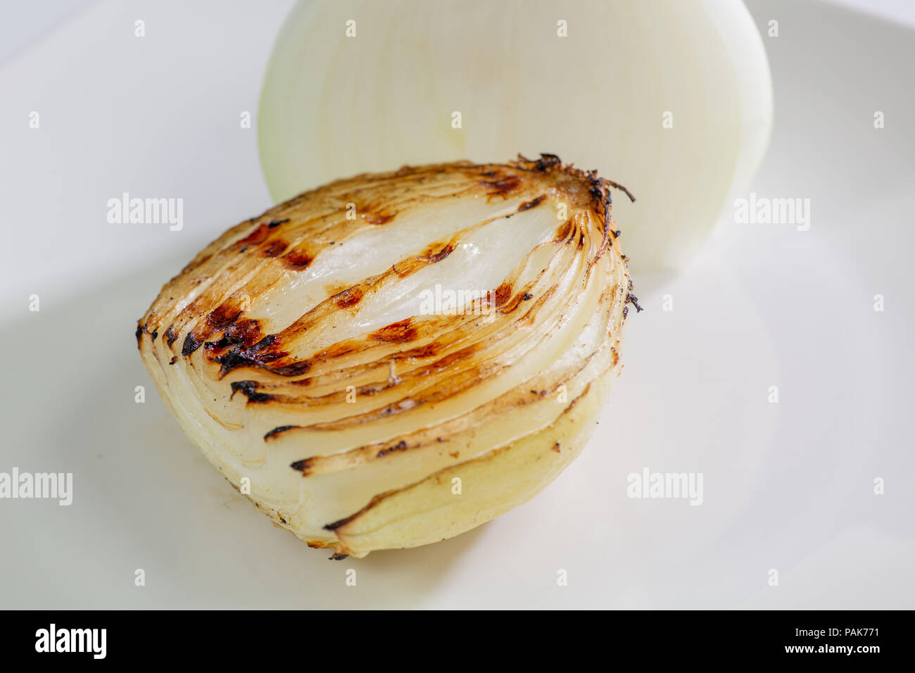 Cebolla asada recién sacados de la parrilla y se colocan en una placa blanca en la mesa Fotografía de - Alamy