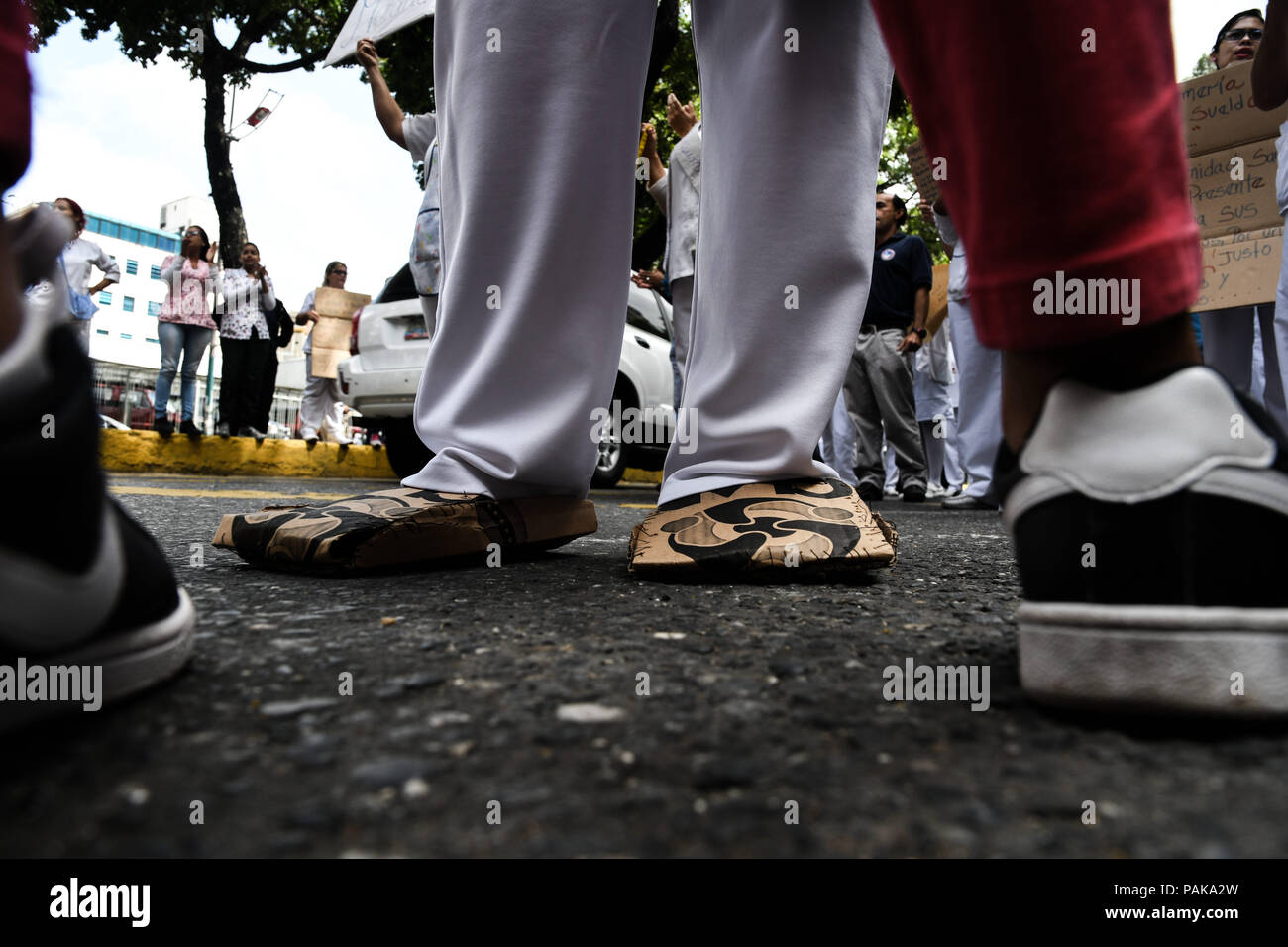 Caracas, Distrito Capital, Venezuela. 23 de julio de 2018. Una enfermera  zapatos realizados desde la caja de alimentos proporcionada por el gobierno  de Nicolás Maduro (CLAP) fuera del hospital.El personal médico de