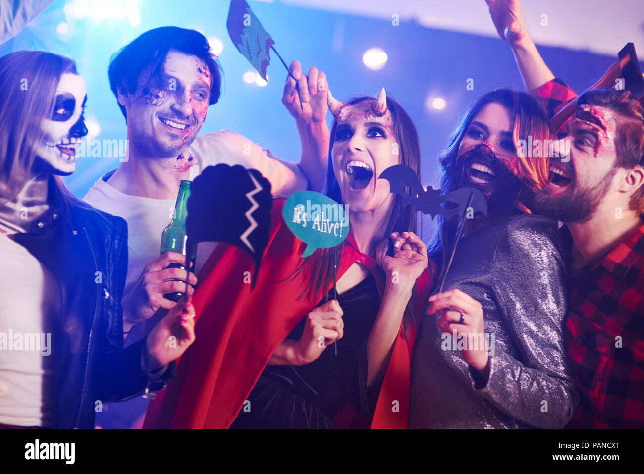Amigos en creepy trajes divirtiéndose en la fiesta de Halloween Foto de stock