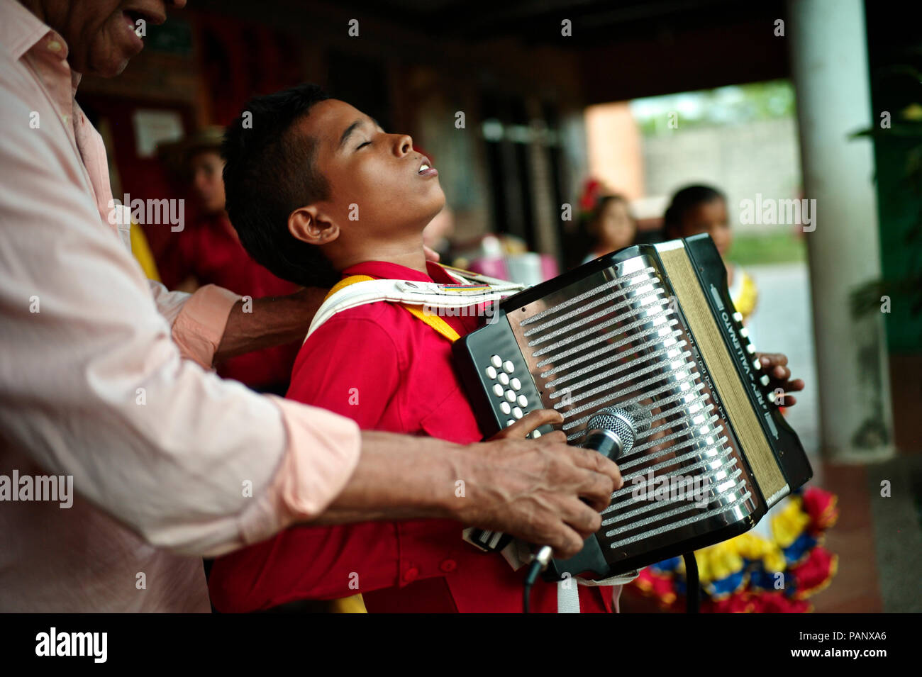 Andrés "Turco" Gil por la academia de acordeón entrena a los niños pequeños en la música de vallenato, muchos de ellos son refugiados de la violencia o que viven en la pobreza Foto de stock