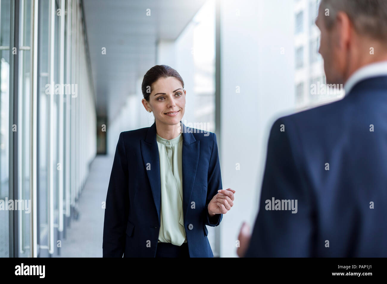 Retrato de la empresaria sonriente escuchando business partner Foto de stock