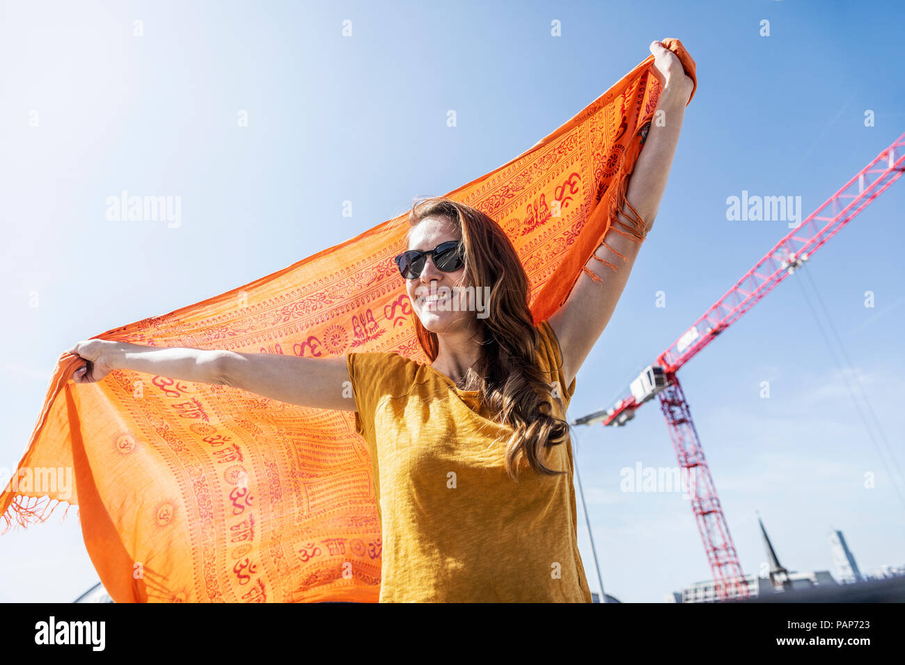 Retrato de mujer sonriente con gafas de sol y la tela Foto de stock