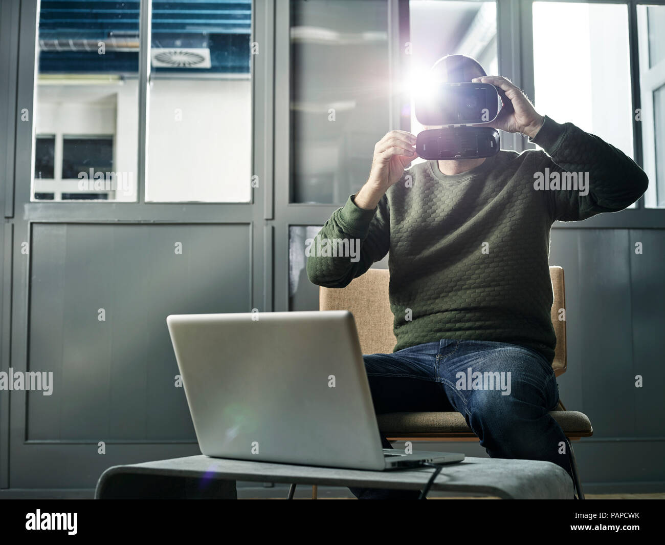Hombre trabajando con VR gafas y portátil Foto de stock